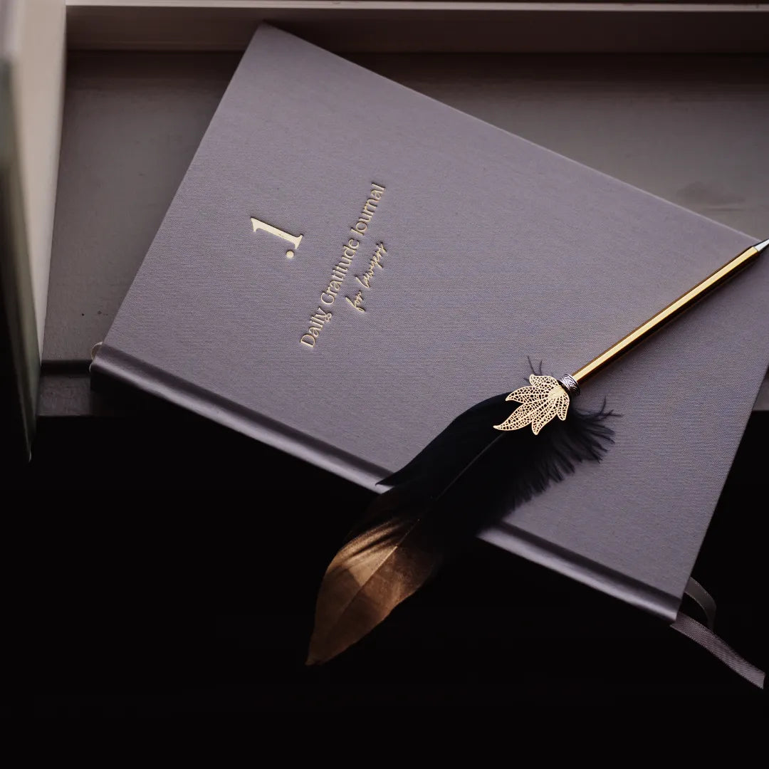 Dark leather journal with gold feather quill on a dark background titled '.1 Daily Gratitude Journal for Lawyers'