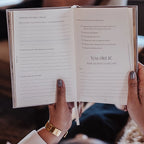 Open book held by hands with a motivational message on a blurred background