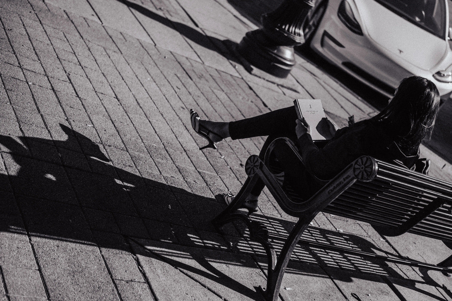 Person sitting on a bench with the .1 daily gratitude journal for lawyers with a car in the background