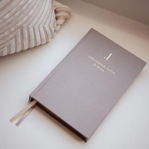 Gray journal titled '.1 Daily Gratitude Journal for Lawyers' on a light surface