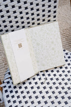 Open notebook with textured cover on a woven chair