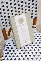 Book with a white cover and gold text on a black and white checkered chair