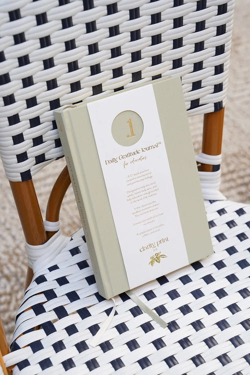 Book with a white cover and gold text on a black and white checkered chair