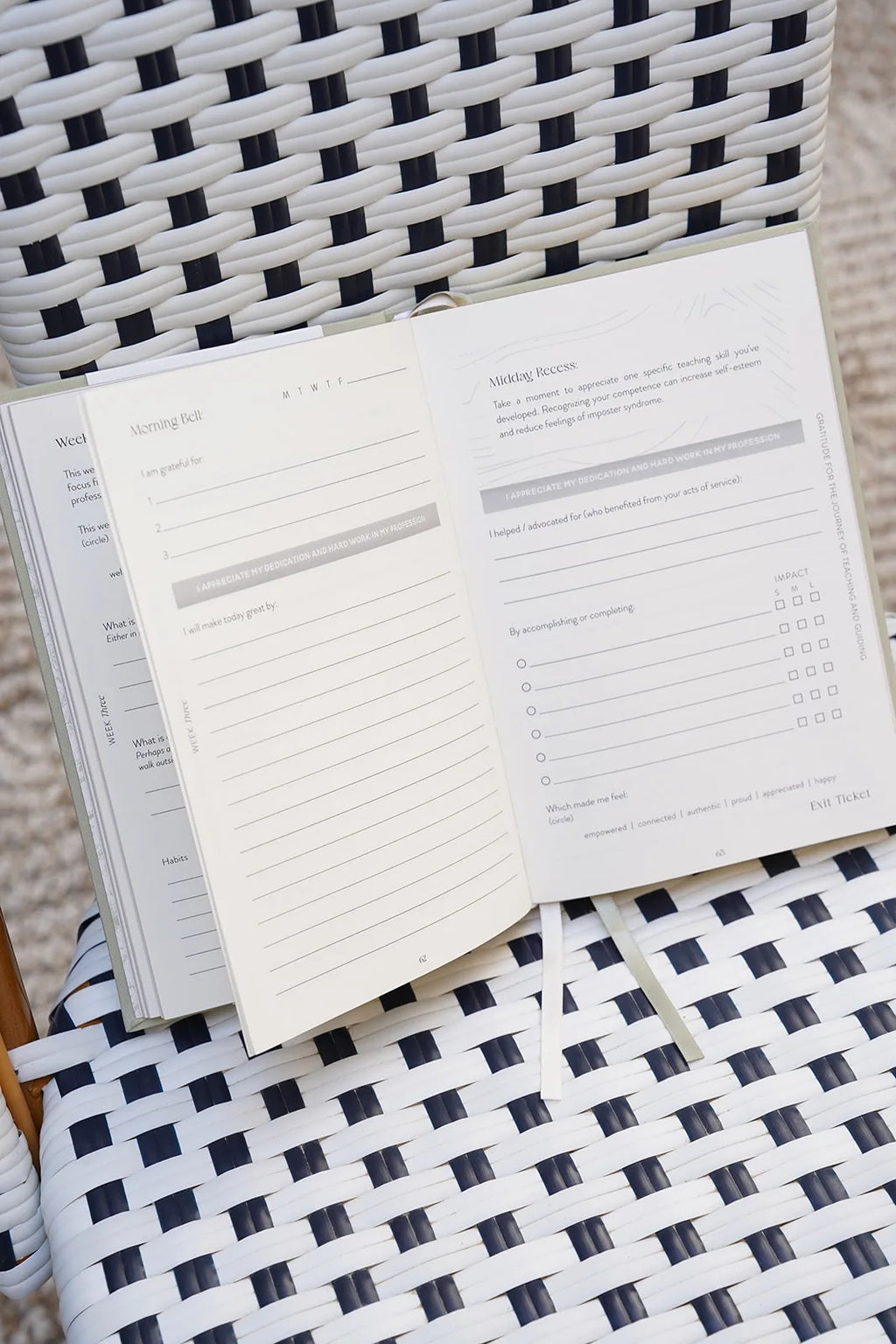 Open planner on a woven chair with a checkered pattern