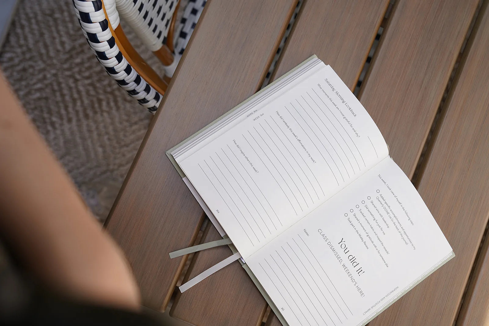 Open book on a wooden surface with a blurred person and basket in the background