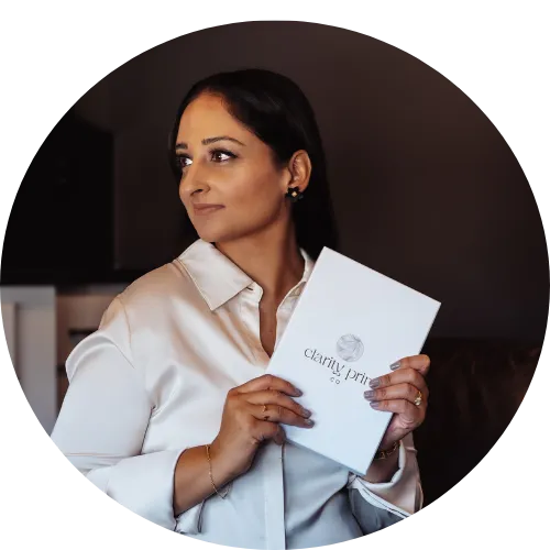 Woman holding a 'Clarity Print Co' book in a dimly lit room
